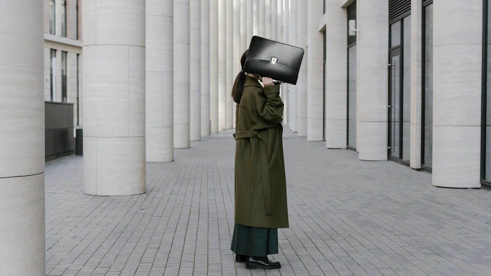 Person mit Aktentasche vor moderner Architektur als Symbol für fehlende Sichtbarkeit